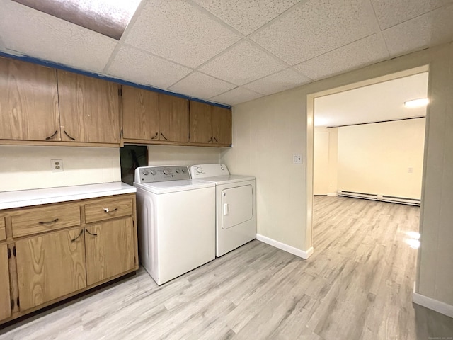 laundry room with cabinets, separate washer and dryer, light wood-type flooring, and baseboard heating