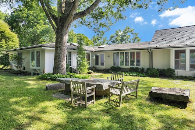 rear view of property featuring a lawn