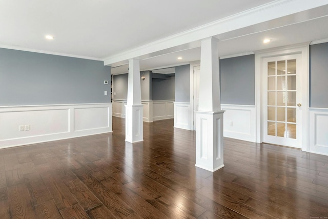 unfurnished room featuring crown molding, dark wood-type flooring, and decorative columns