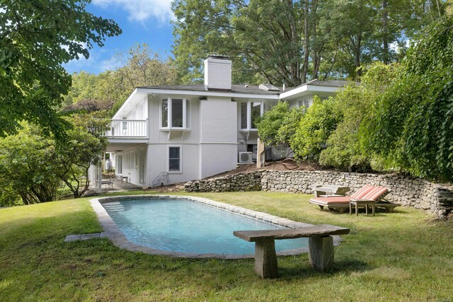 back of property featuring a balcony, a yard, and cooling unit