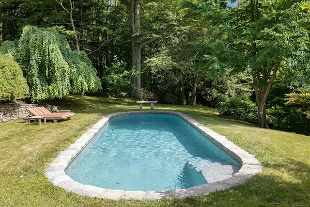 view of pool featuring a lawn