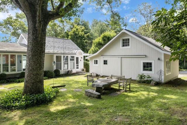 rear view of property featuring a lawn