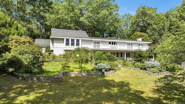 rear view of house featuring a lawn