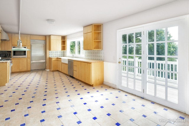 kitchen with tasteful backsplash, appliances with stainless steel finishes, light brown cabinets, and decorative light fixtures