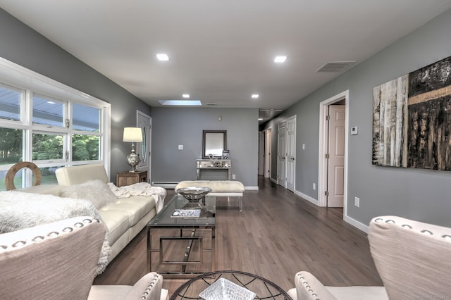 living room featuring a baseboard heating unit and dark hardwood / wood-style flooring