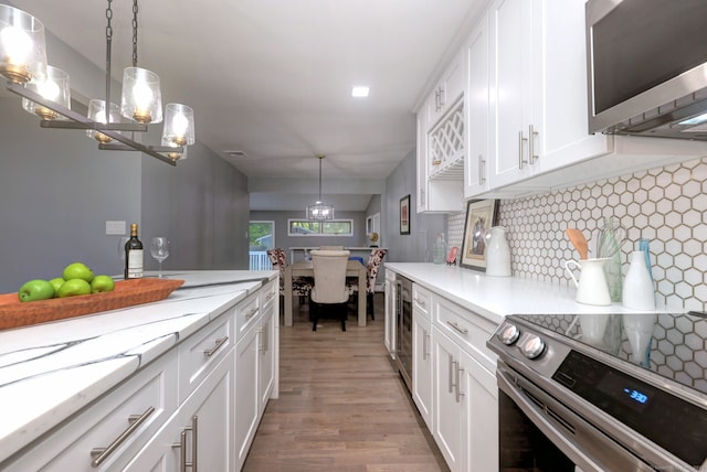 kitchen featuring white cabinets, pendant lighting, and appliances with stainless steel finishes