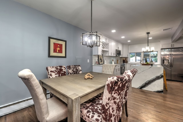 dining area with baseboard heating, dark hardwood / wood-style flooring, and a notable chandelier