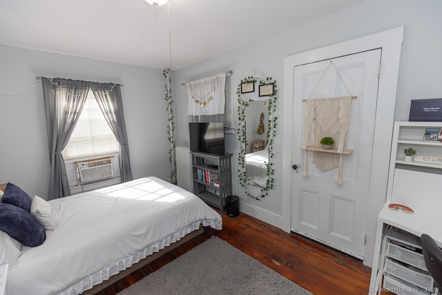 bedroom with cooling unit and dark hardwood / wood-style floors