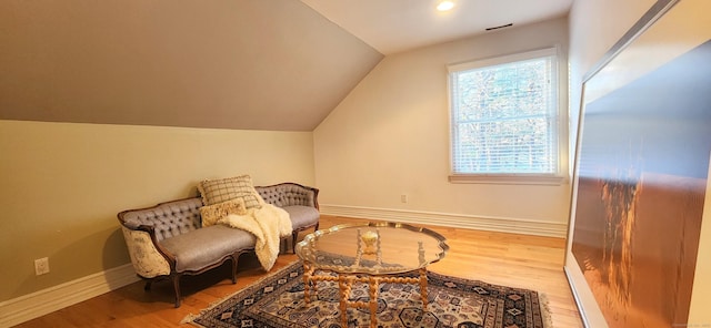 sitting room featuring vaulted ceiling, baseboards, and wood finished floors