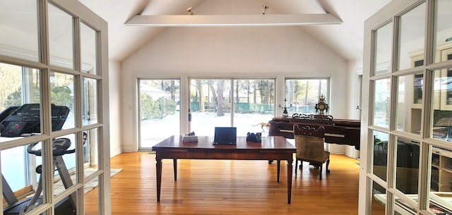 interior space with beam ceiling, light wood-style flooring, french doors, and high vaulted ceiling