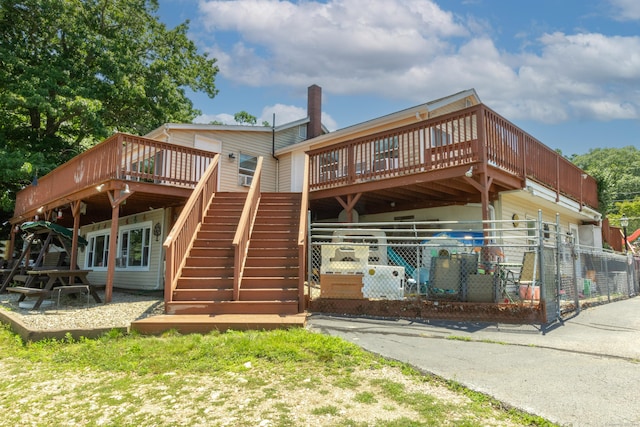 rear view of property featuring a wooden deck