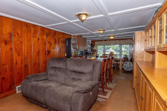 carpeted living room featuring wooden walls and coffered ceiling