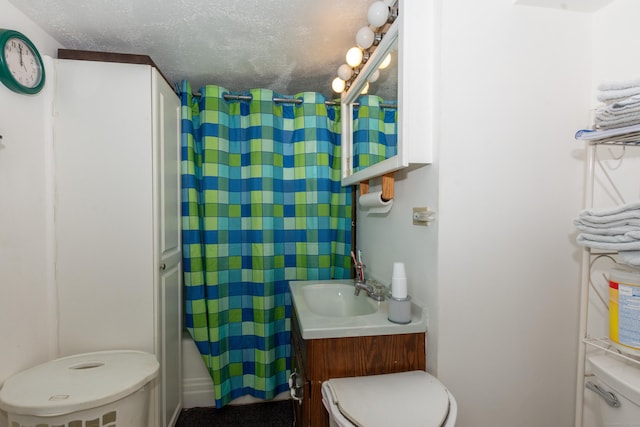 bathroom with curtained shower, vanity, a textured ceiling, and toilet