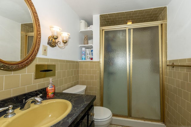 bathroom featuring an enclosed shower, vanity, toilet, and tile walls