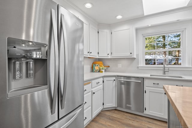 kitchen featuring white cabinetry, sink, wood counters, and appliances with stainless steel finishes