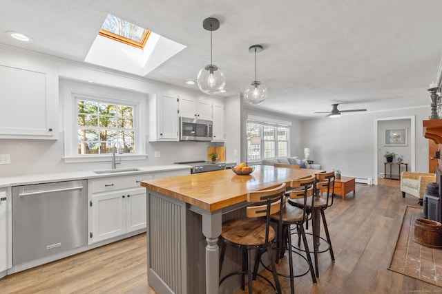 kitchen featuring appliances with stainless steel finishes, a breakfast bar, sink, and white cabinets