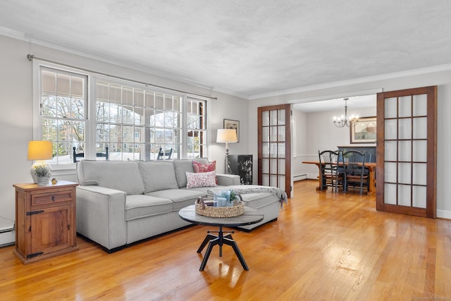 living room with crown molding, a baseboard heating unit, light hardwood / wood-style floors, a textured ceiling, and a chandelier