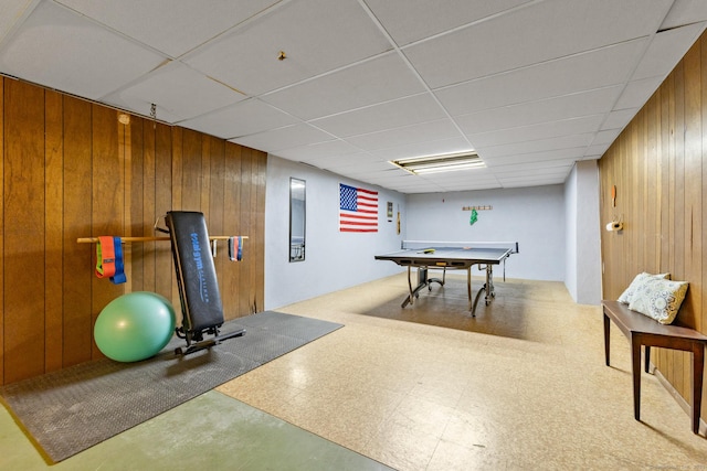 playroom with a paneled ceiling and wooden walls