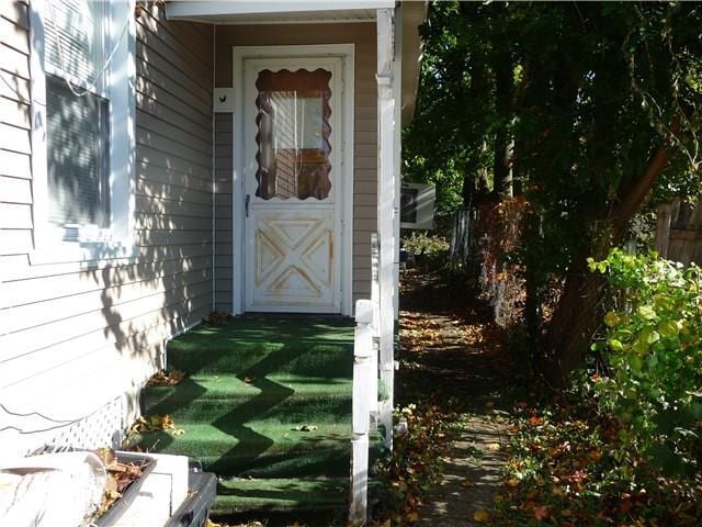 doorway to property with a lawn