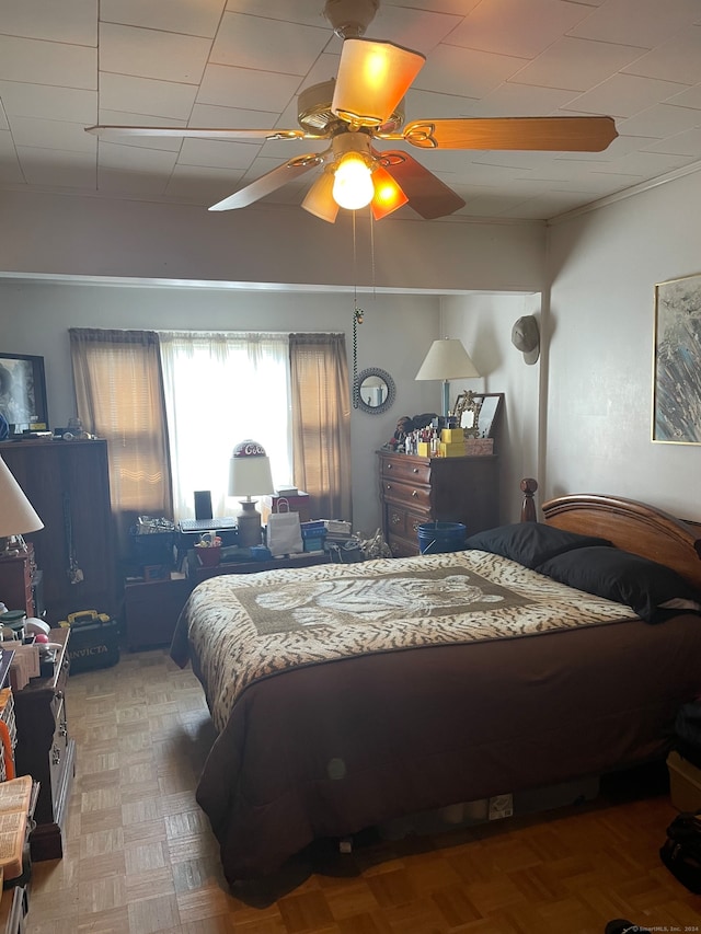 bedroom with ceiling fan and parquet flooring