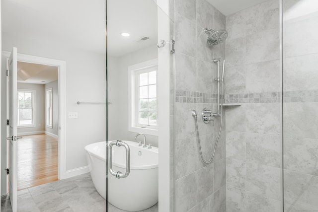 bathroom with independent shower and bath and hardwood / wood-style flooring