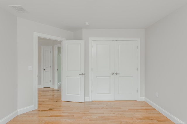 unfurnished bedroom featuring light hardwood / wood-style floors and a closet