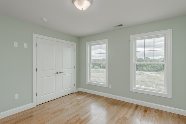 unfurnished bedroom featuring a closet and light wood-type flooring