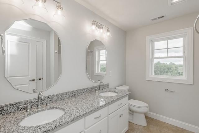 bathroom featuring tile patterned flooring, toilet, and dual bowl vanity