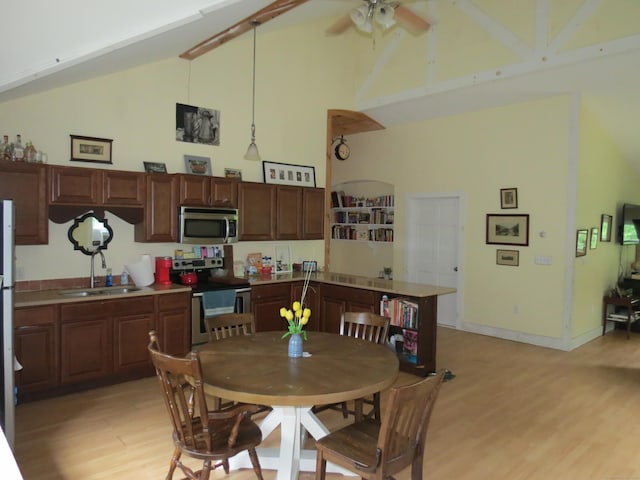 dining area featuring high vaulted ceiling, sink, ceiling fan, and light hardwood / wood-style flooring