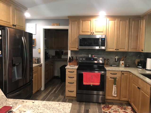 kitchen with light stone counters, dark hardwood / wood-style flooring, appliances with stainless steel finishes, light brown cabinetry, and decorative backsplash