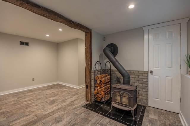 room details with beam ceiling and a wood stove