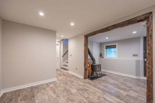 unfurnished living room with light wood-type flooring and a wood stove