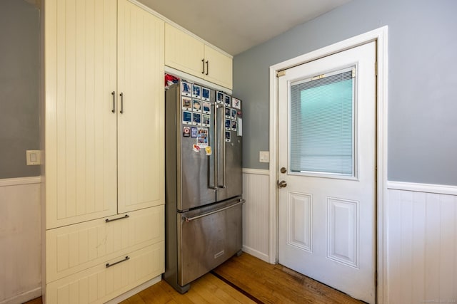 kitchen with high quality fridge and hardwood / wood-style floors