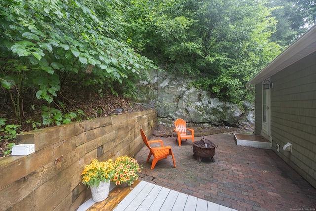 wooden terrace featuring a patio area and a fire pit