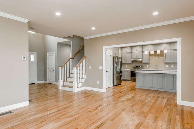 interior space featuring gray cabinets, light hardwood / wood-style flooring, appliances with stainless steel finishes, and sink