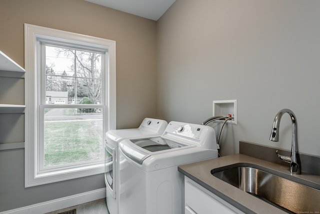 washroom featuring sink, washer and dryer, and a healthy amount of sunlight