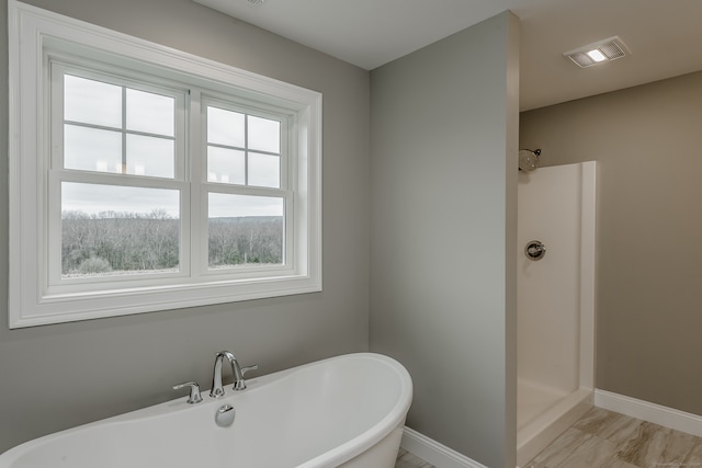 bathroom with a wealth of natural light, hardwood / wood-style flooring, and walk in shower