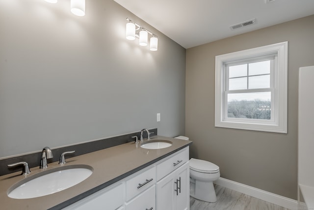 bathroom featuring double vanity and toilet