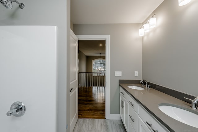 bathroom with wood-type flooring and dual bowl vanity