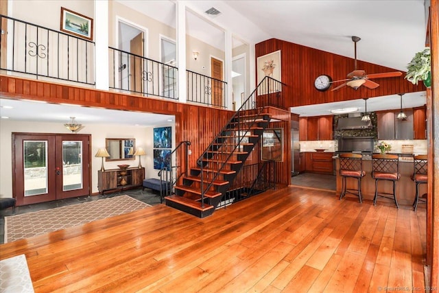 interior space with french doors, high vaulted ceiling, ceiling fan, and wood-type flooring