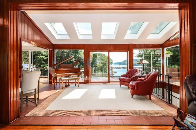 sunroom / solarium with a water view and lofted ceiling