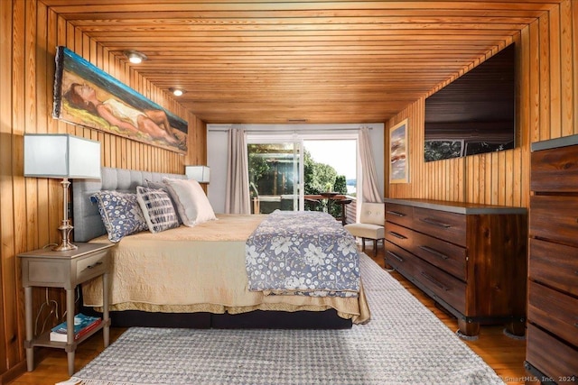 bedroom with access to exterior, wood walls, wood ceiling, and hardwood / wood-style flooring