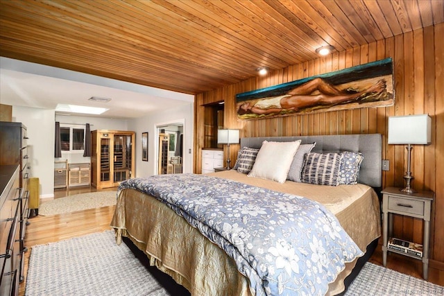 bedroom with wooden walls, hardwood / wood-style flooring, and wooden ceiling