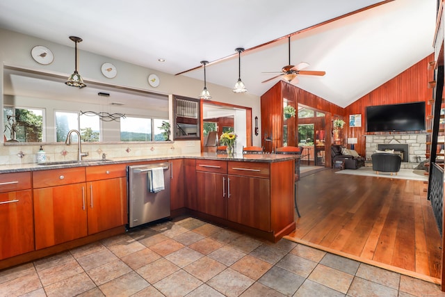 kitchen featuring kitchen peninsula, a fireplace, sink, and decorative light fixtures