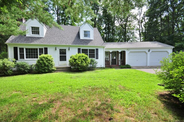 cape cod house with a garage and a front yard