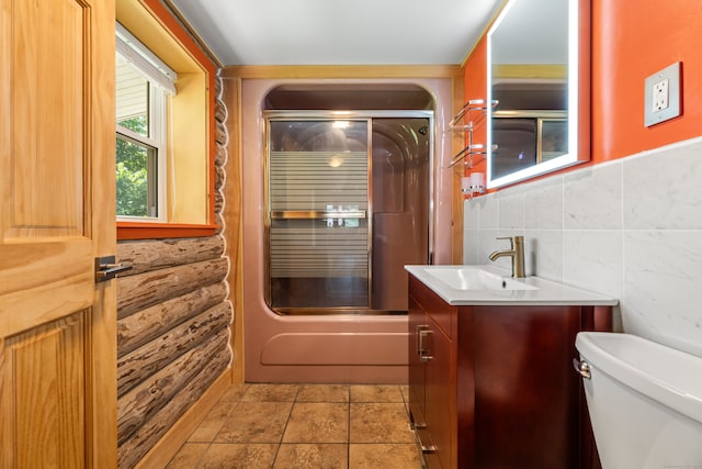 full bathroom with shower / bath combination with glass door, decorative backsplash, tile patterned floors, toilet, and vanity