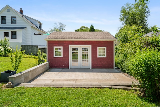 exterior space featuring a patio, an outdoor structure, french doors, and a lawn