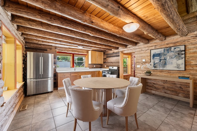 dining space featuring beam ceiling, sink, light tile patterned floors, and wooden ceiling