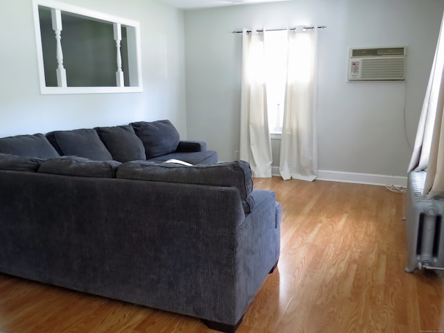 living room featuring light hardwood / wood-style flooring and an AC wall unit