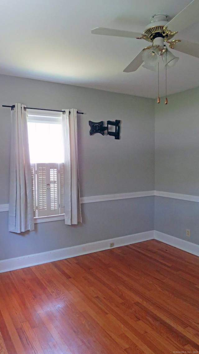 empty room with ceiling fan and hardwood / wood-style flooring